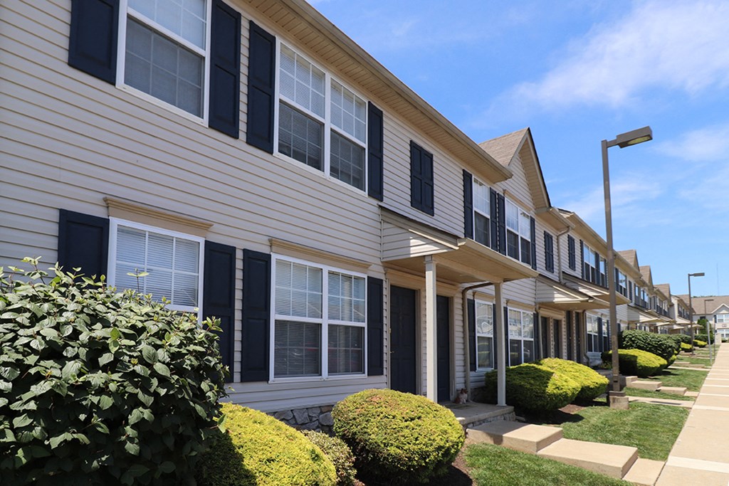 a row of townhomes with black and white siding and landscaping