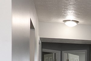 an empty living room with wood flooring and a bathroom