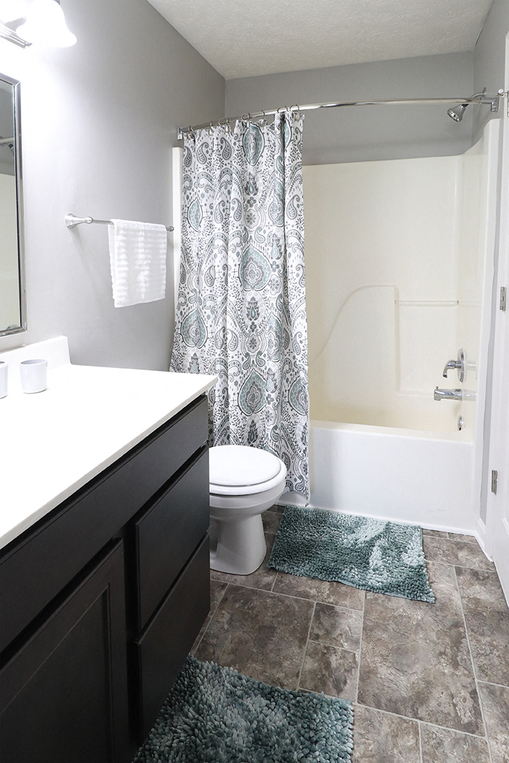 a bathroom with a toilet and a shower and a sink