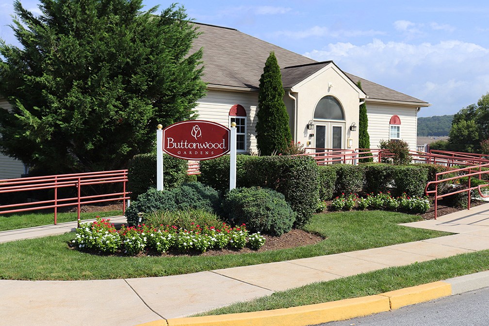 a building with a sign in front of a garden