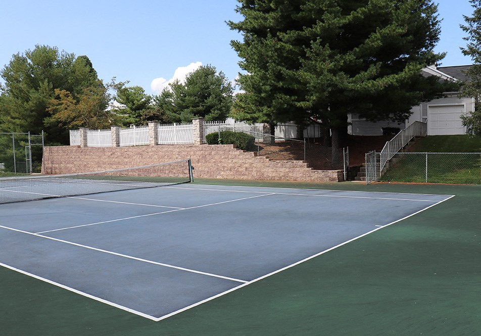a tennis court in front of a house