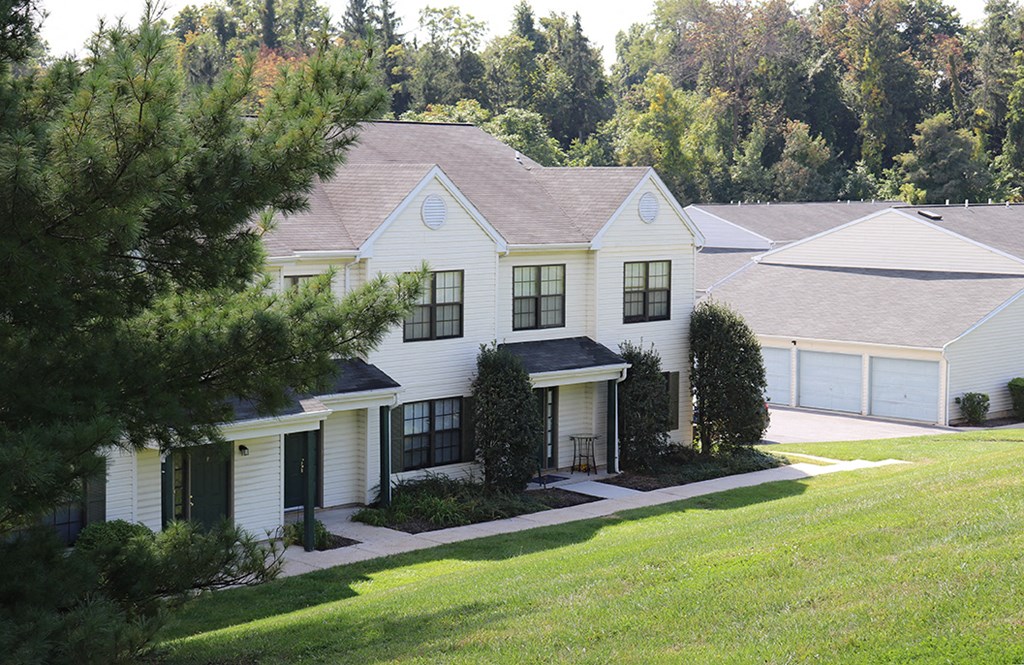 a white house with black shutters and a lawn