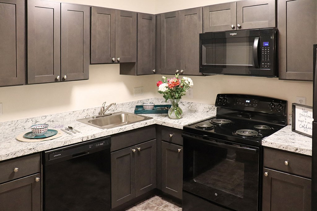 a kitchen with black appliances and granite counter tops