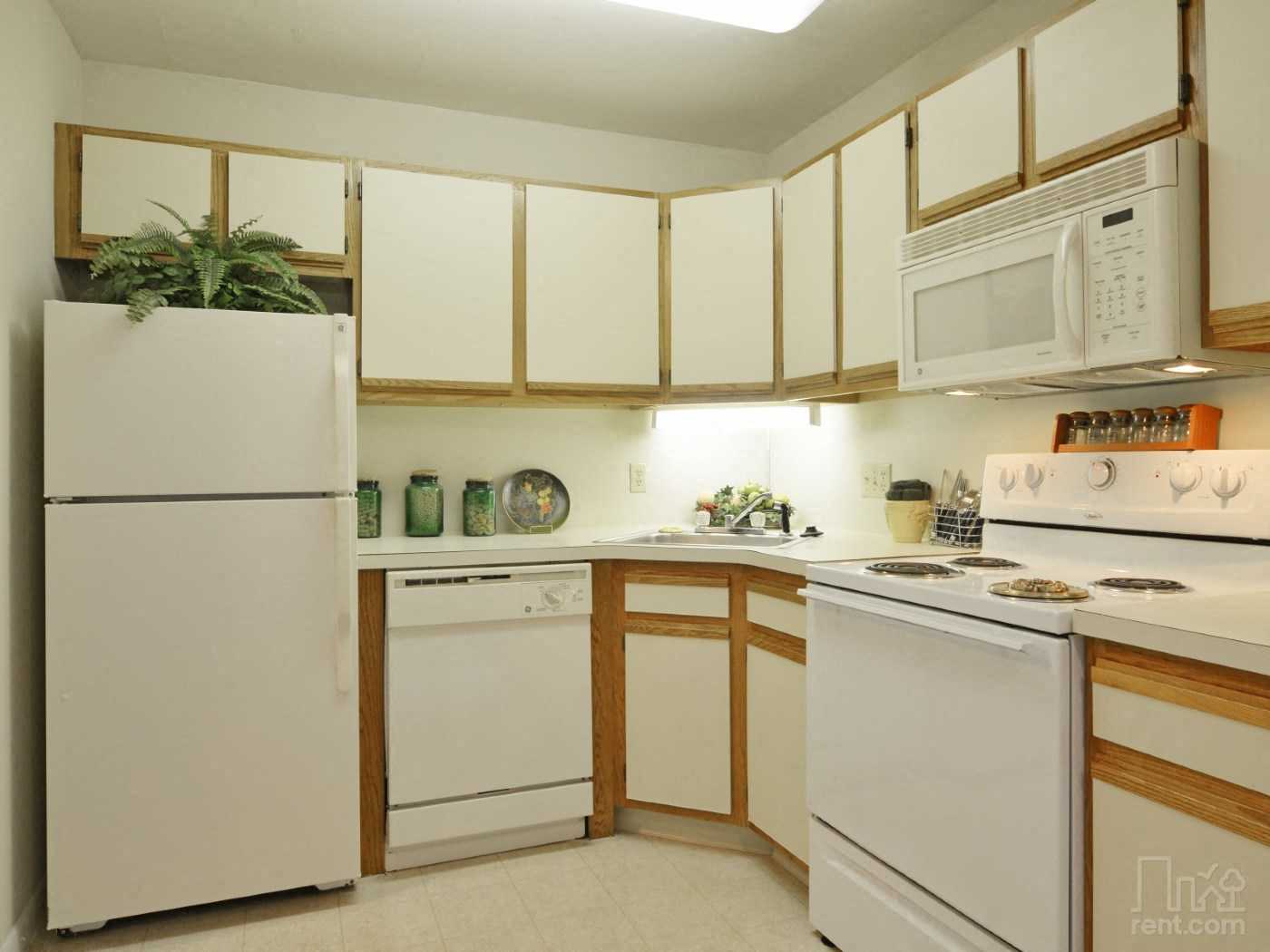 a kitchen with white appliances and wooden cabinets