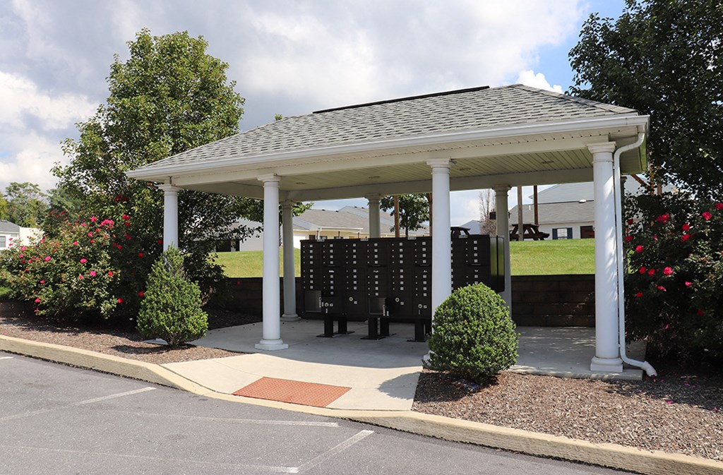 a gazebo with a table and chairs in a parking lot