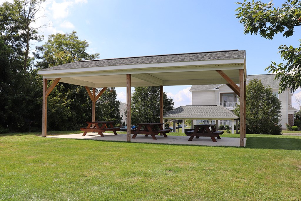 a pavilion with picnic tables in a park