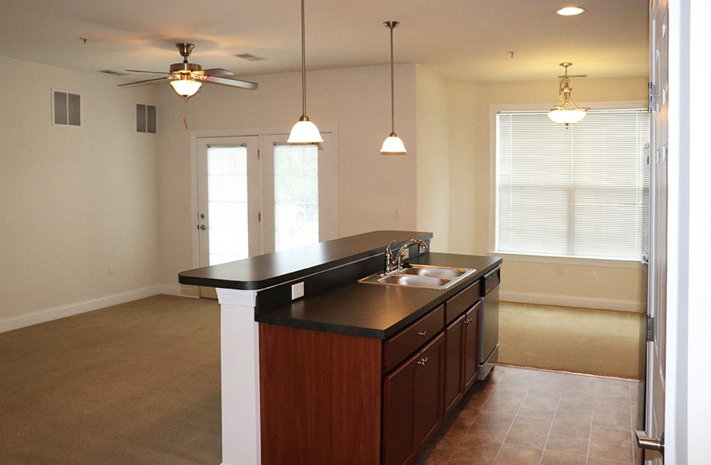 an empty kitchen with a sink and a ceiling fan