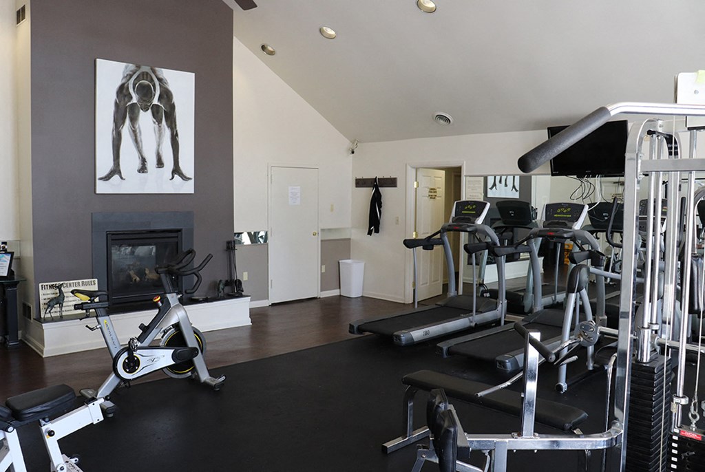 a home gym with exercise equipment and a fireplace