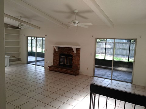 A living room with a fireplace and sliding glass doors.