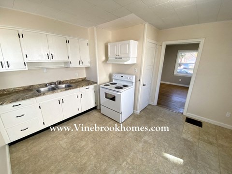 a kitchen with white cabinets and a stove and a sink