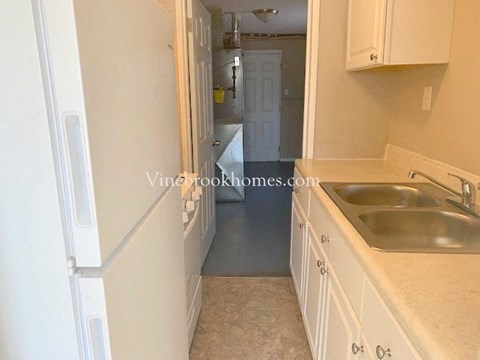 a small kitchen with a sink and a refrigerator