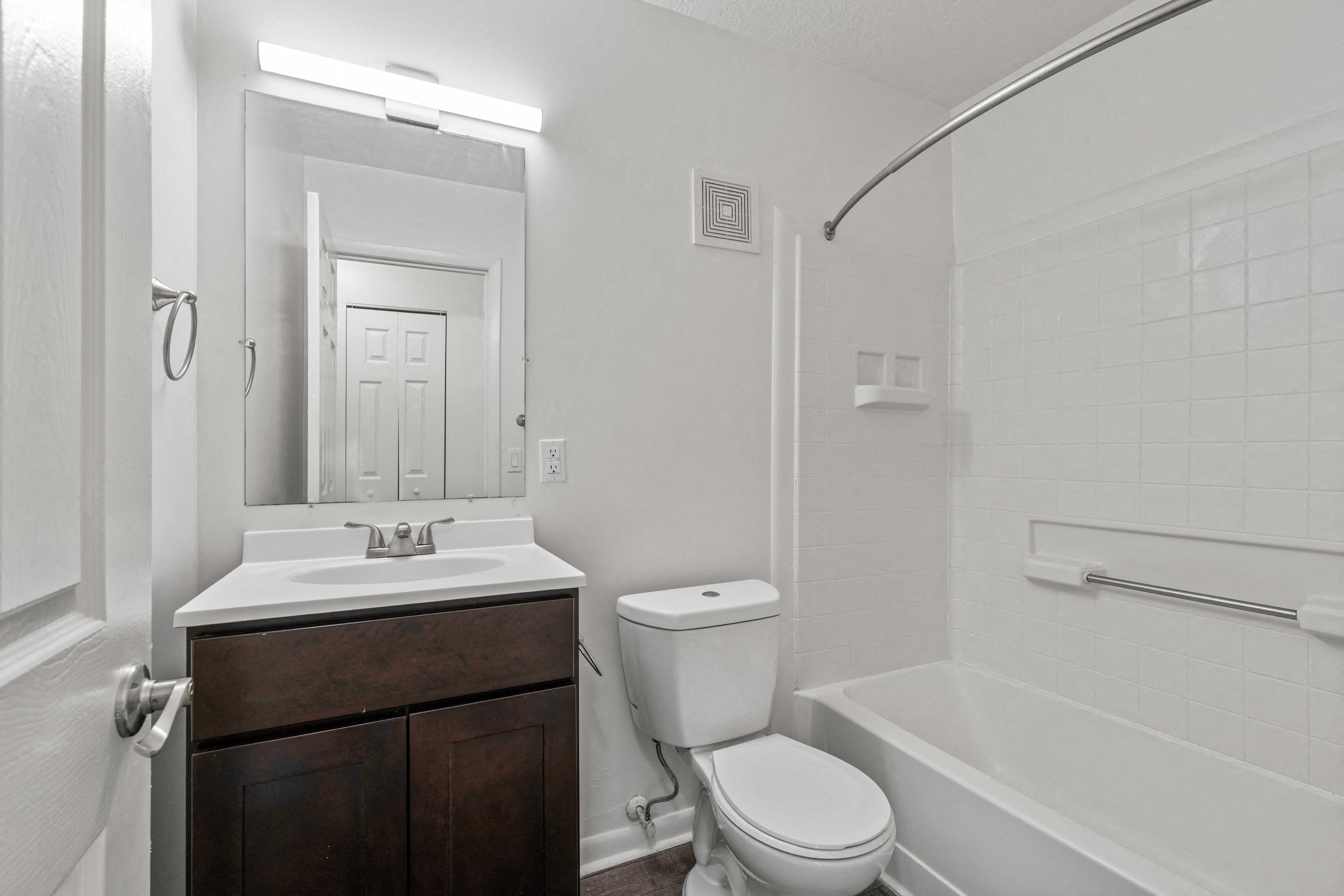A white bathroom with a toilet, sink, and bathtub.