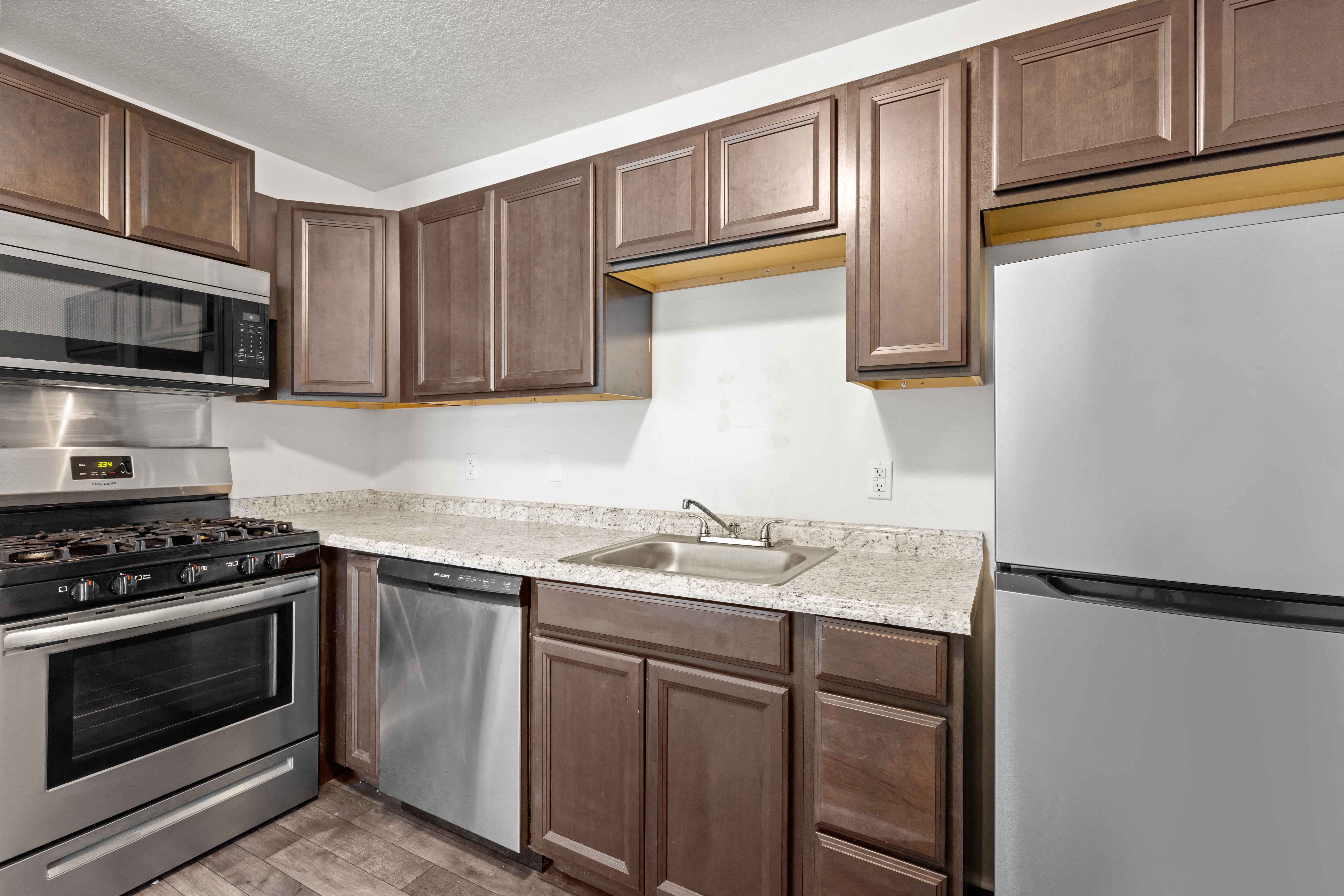 A kitchen with brown cabinets and a white refrigerator.
