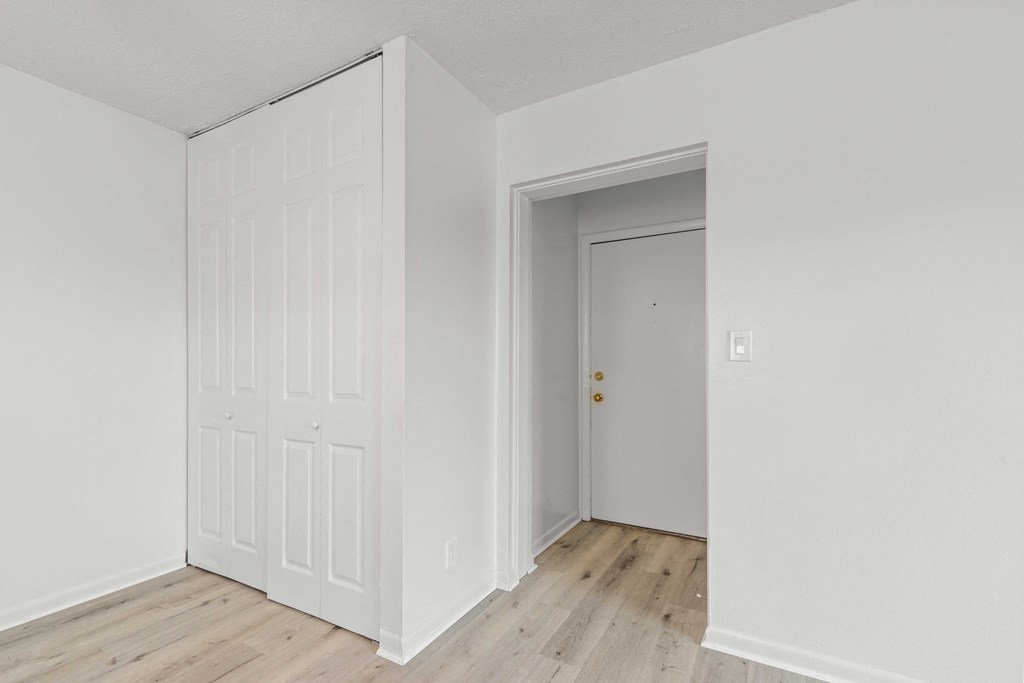 A white door is in a room with a wooden floor.