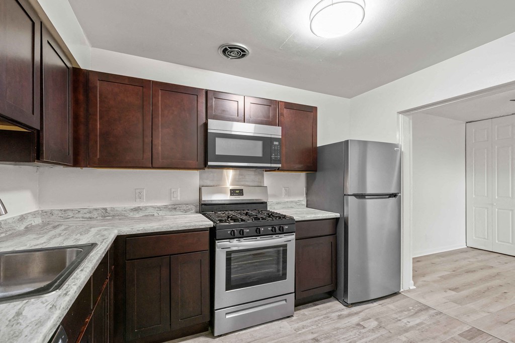 A kitchen with brown cabinets and stainless steel appliances.