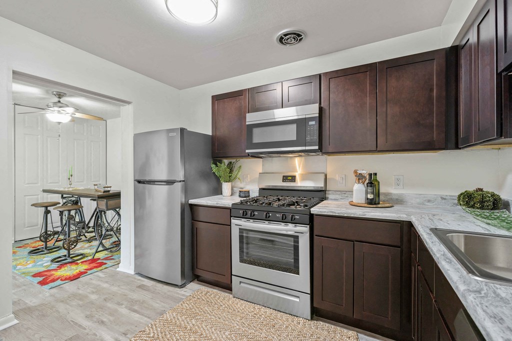 A kitchen with a refrigerator, oven, and microwave.