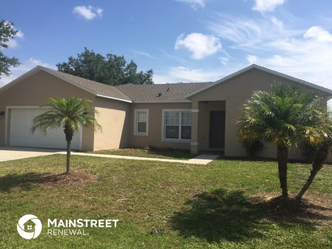 a home with two palm trees in front of it