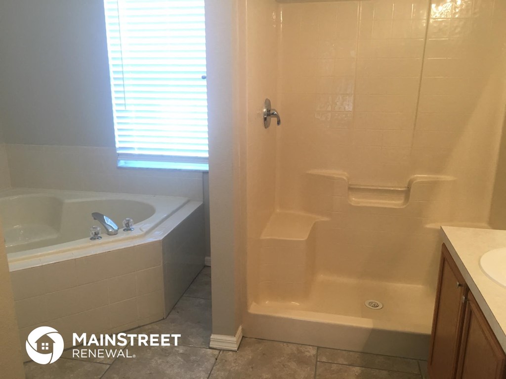 a bathroom with a tub and a shower and a sink