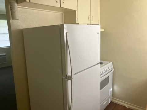 A white refrigerator and oven in a kitchen.