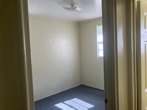 A room with a window and a ceiling fan.