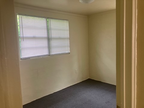 A room with a window and blinds.