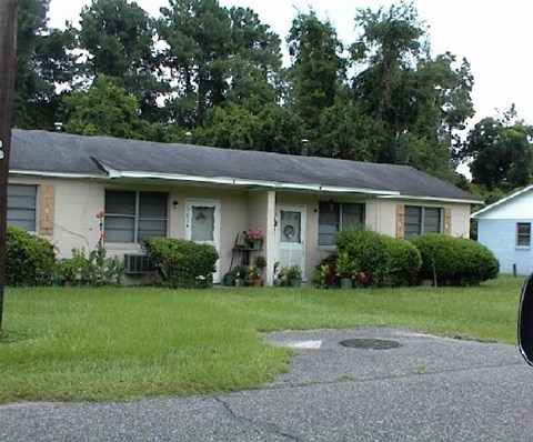 A house with a green lawn and a grey roof.