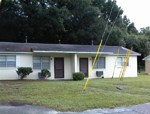 a white house with a yellow ladder in front of it