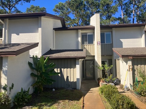 A house with a brown roof and a white wall with a number 2 on it.