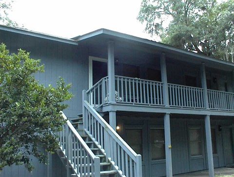 A house with a balcony and stairs leading to it.