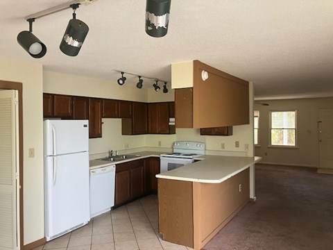 A kitchen with brown cabinets and a white fridge.