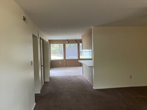 A long hallway with carpeted floors and white walls.