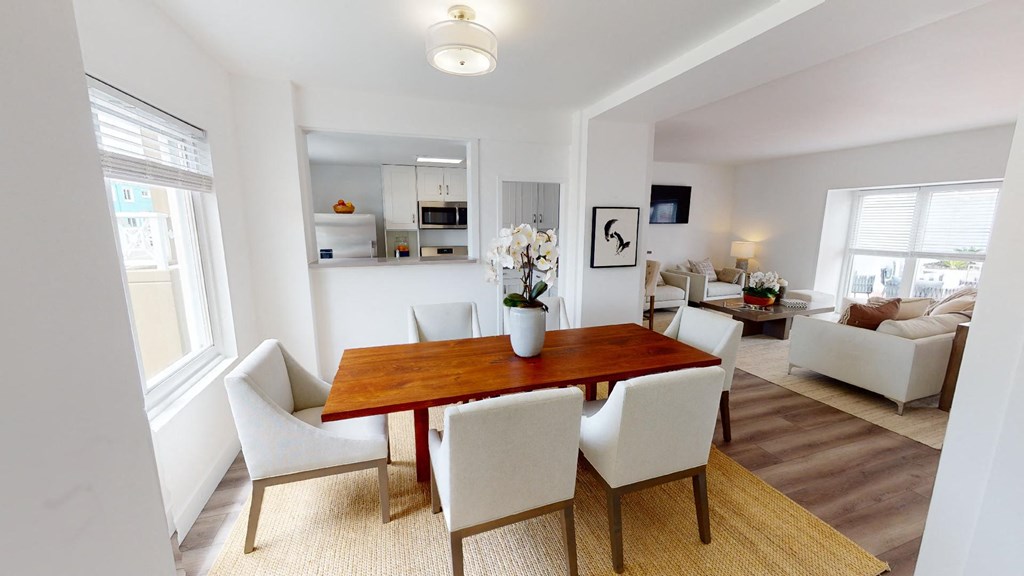 a dining room with a wooden table and white chairs