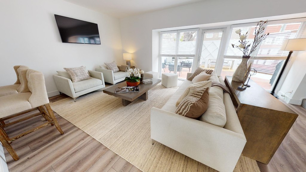 a living room with a couch and chairs and a tv