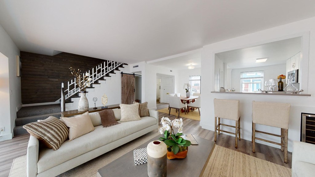 a living room with a white couch and a staircase
