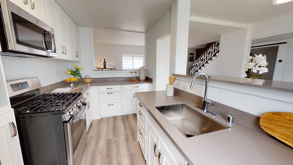 a large kitchen with stainless steel appliances and white cabinets