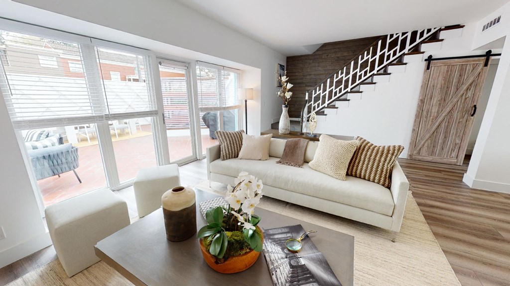 a living room with a white couch and a staircase