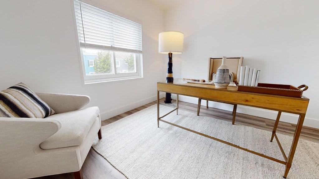 a living room with a couch and a table with a lamp