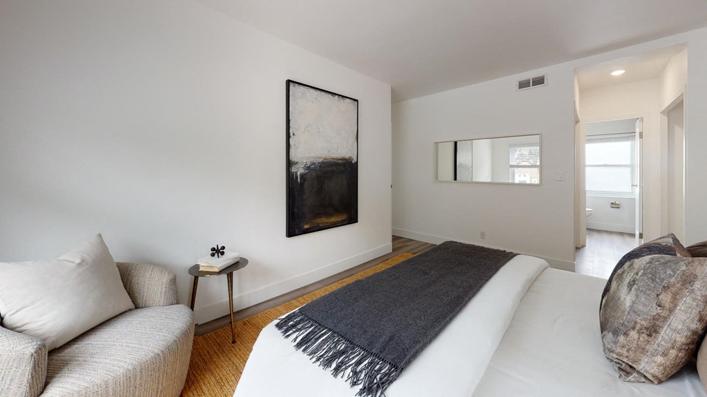 a white bedroom with a bed and a couch