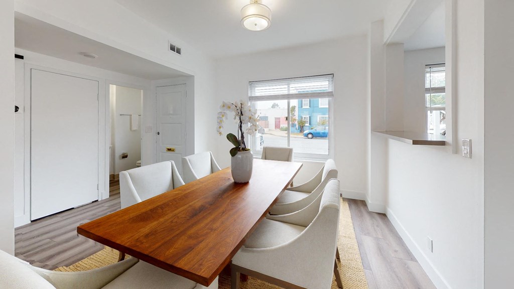 a dining room with a wooden table and white chairs