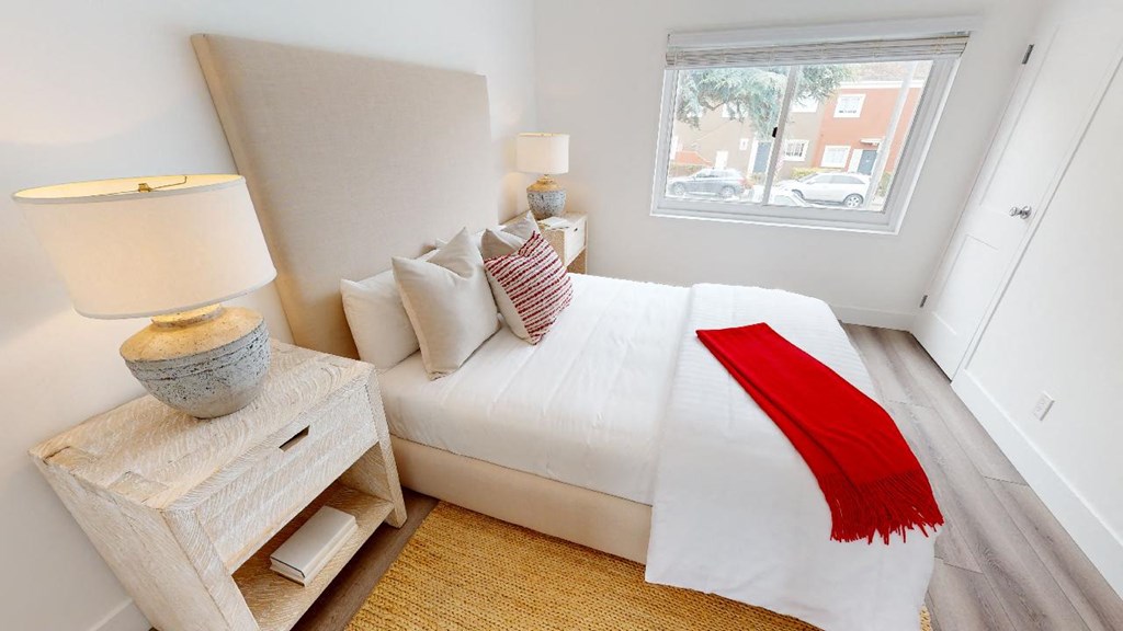 a bedroom with a white bed and a window