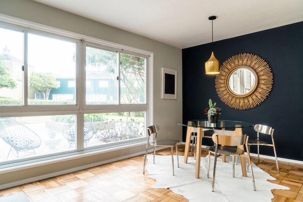 a dining room with a large window and a table and chairs