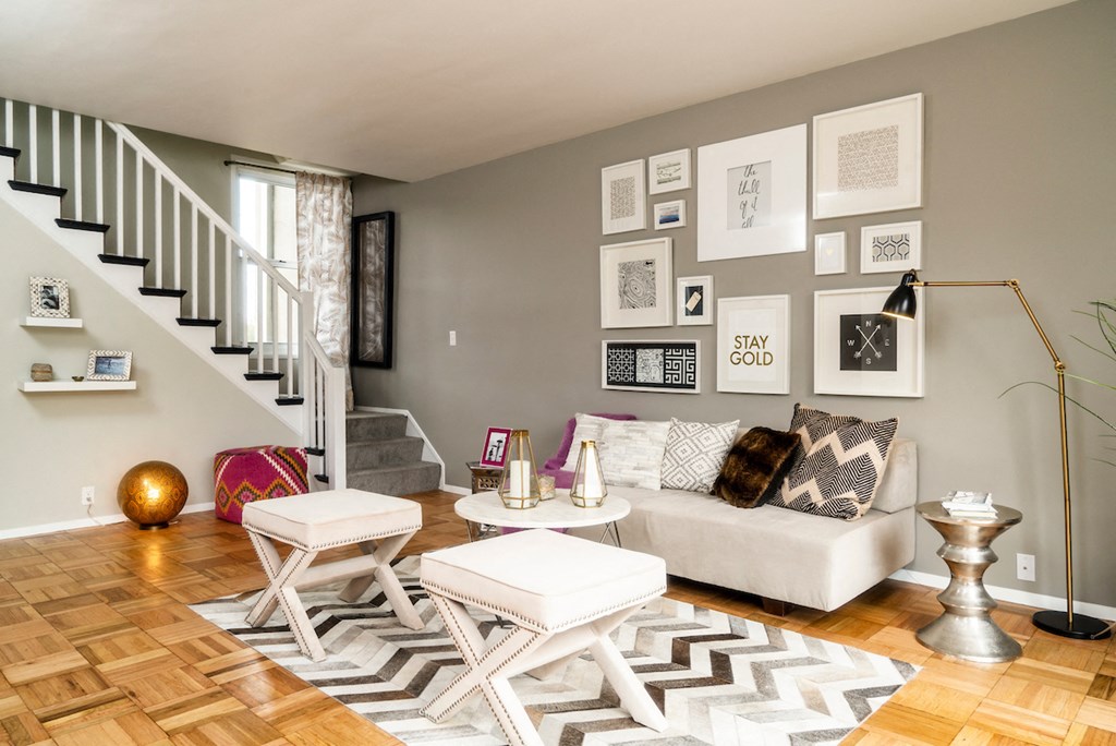 a living room with a white couch and a staircase