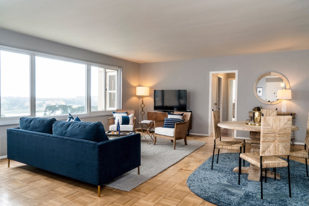 a living room with a blue couch and a table with chairs