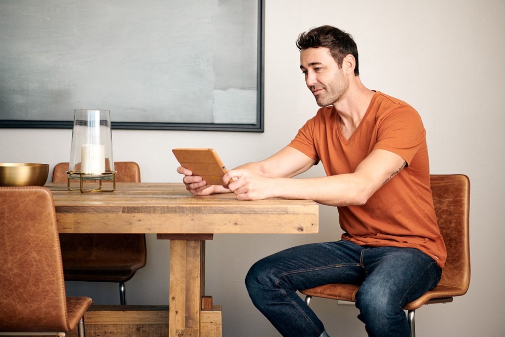 a man sitting at a table using a tablet