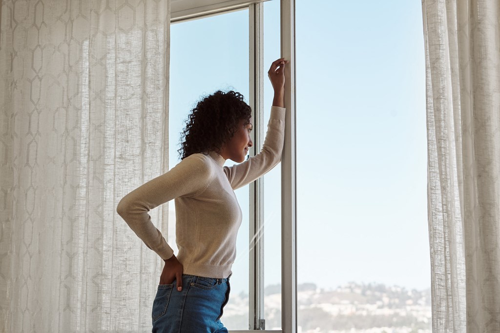 a woman standing in front of a window
