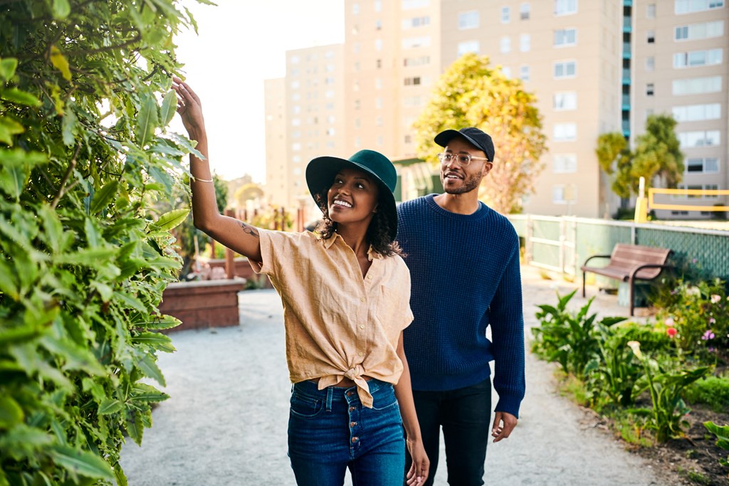 a man and a woman walking through a garden