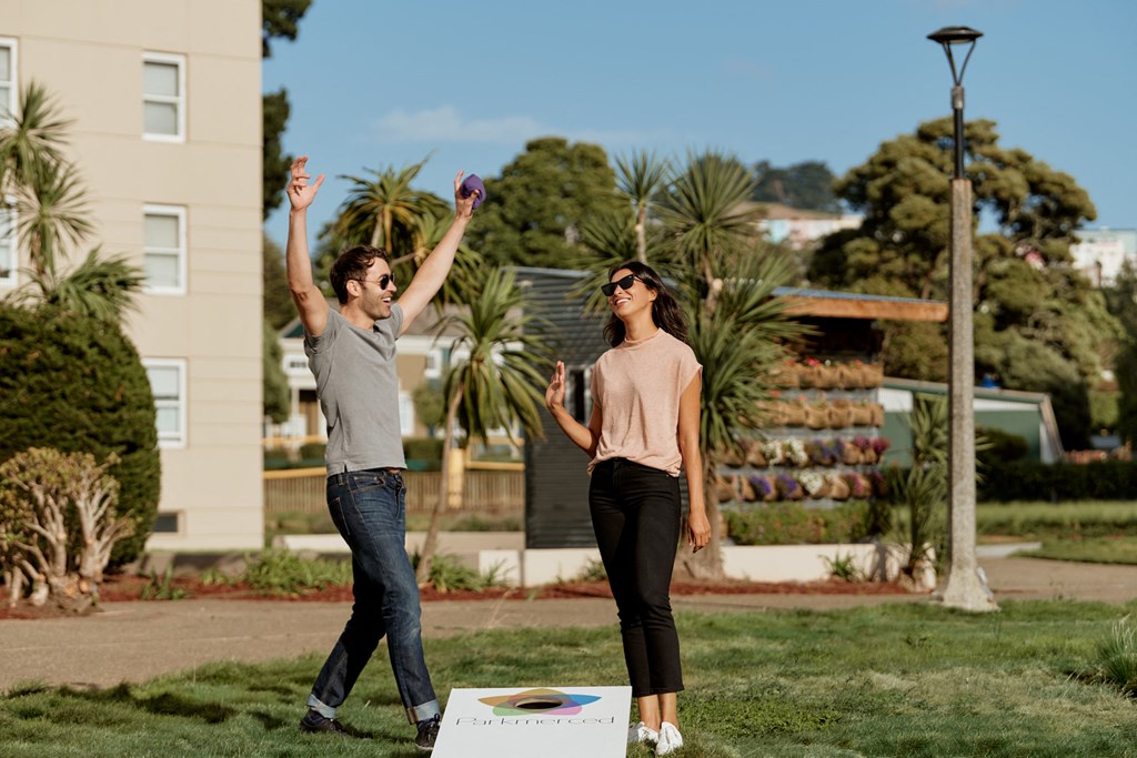 two women playing frisbee in a park