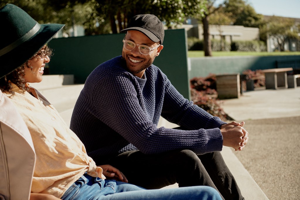 a man and a woman sitting on a park bench