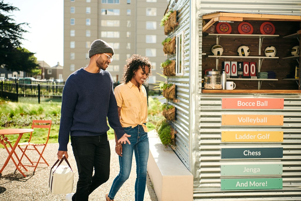 a man and a woman walking past a food stand