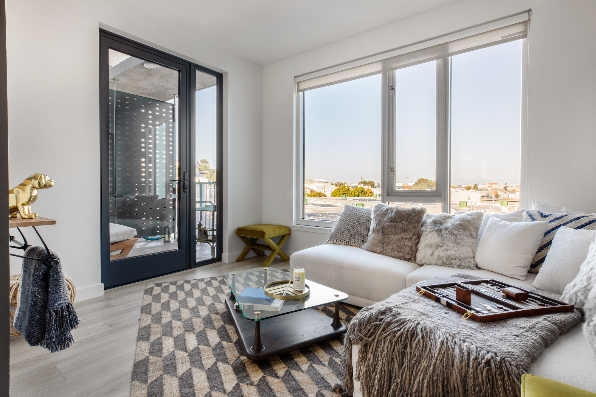 a living room with a couch and a coffee table and large windows